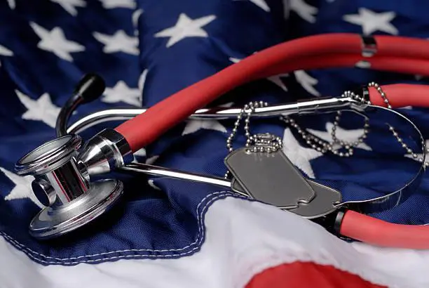 A stethoscope and dog tags on top of an american flag.