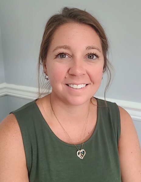 A woman in green shirt smiling for the camera.